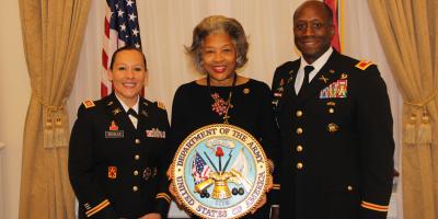 Image of Congresswoman Beatty and members of the Armed Forces holding Department of Army logo.