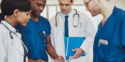 Doctors and nurses look at chart together. 