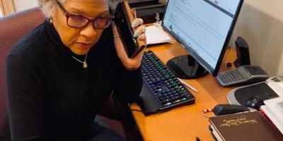 Congresswoman Beatty listens to phone conversation and writes notes.